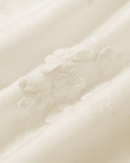 Close-up of cream floral lace embroidery on the fabric