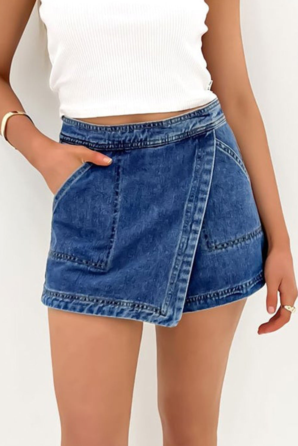 Blue faux-wrapped denim mini skort with crossover front panel and side pocket