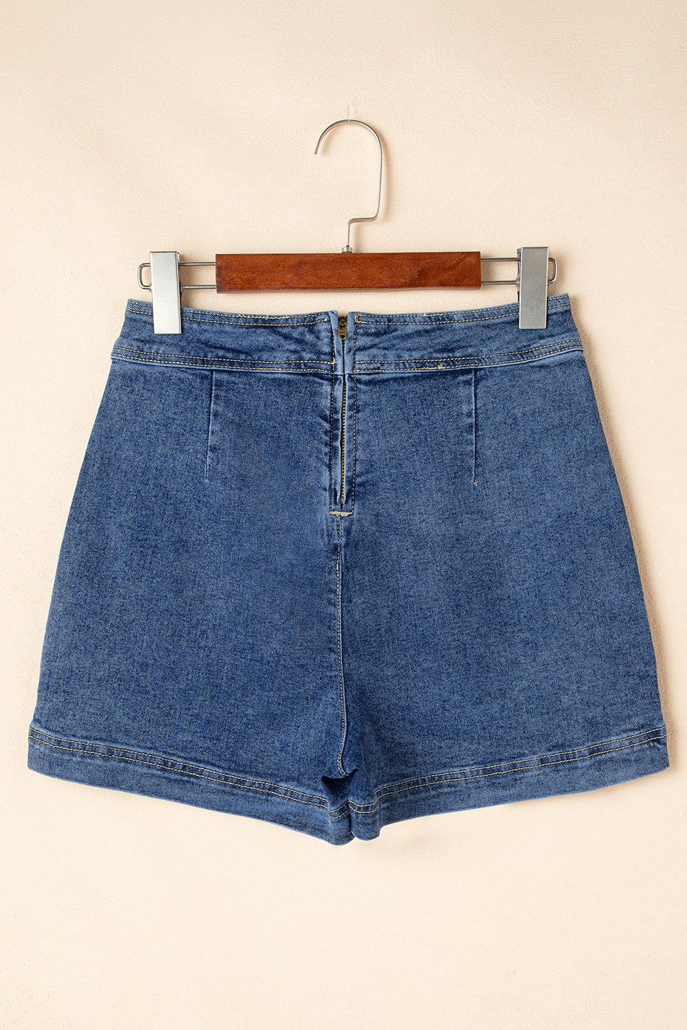 Blue denim mini skort front view, functional pockets and center button placket