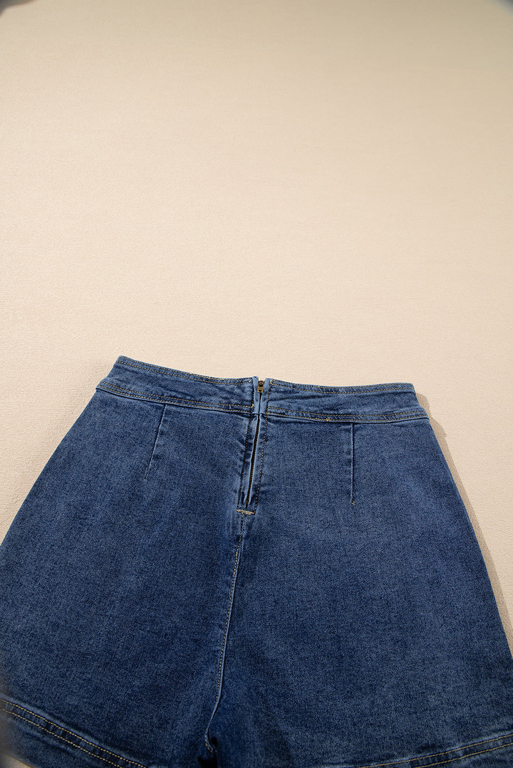 Blue denim mini skort close-up of waistband, zip fly, and front seams