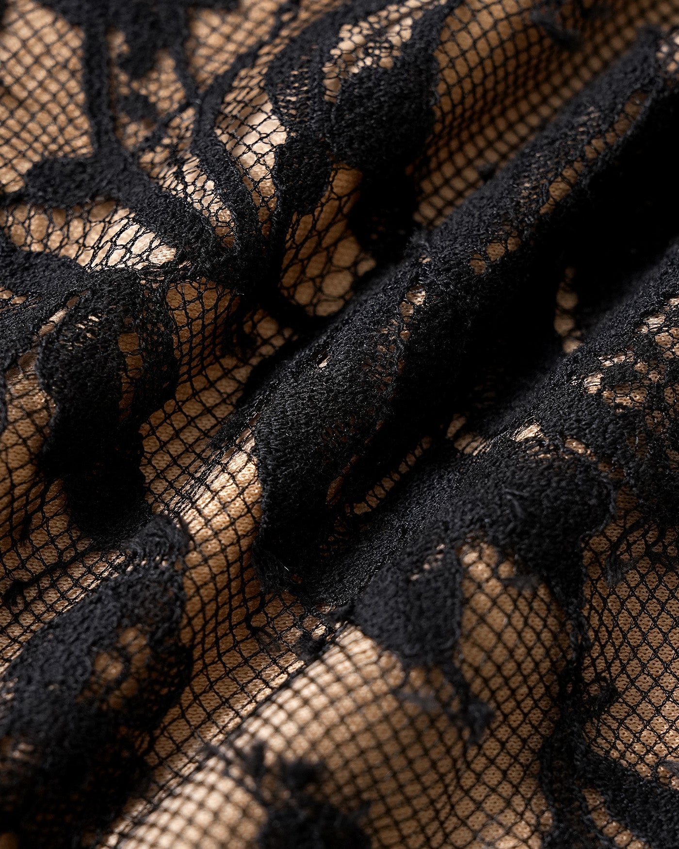 Close-up of black floral lace fabric with textured pattern