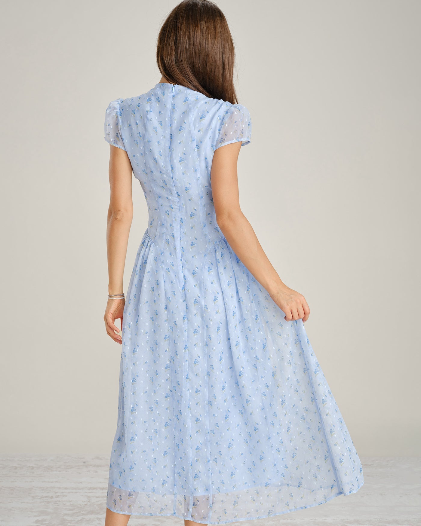 Back view of blue floral chiffon maxi dress with mock neck and short sleeves