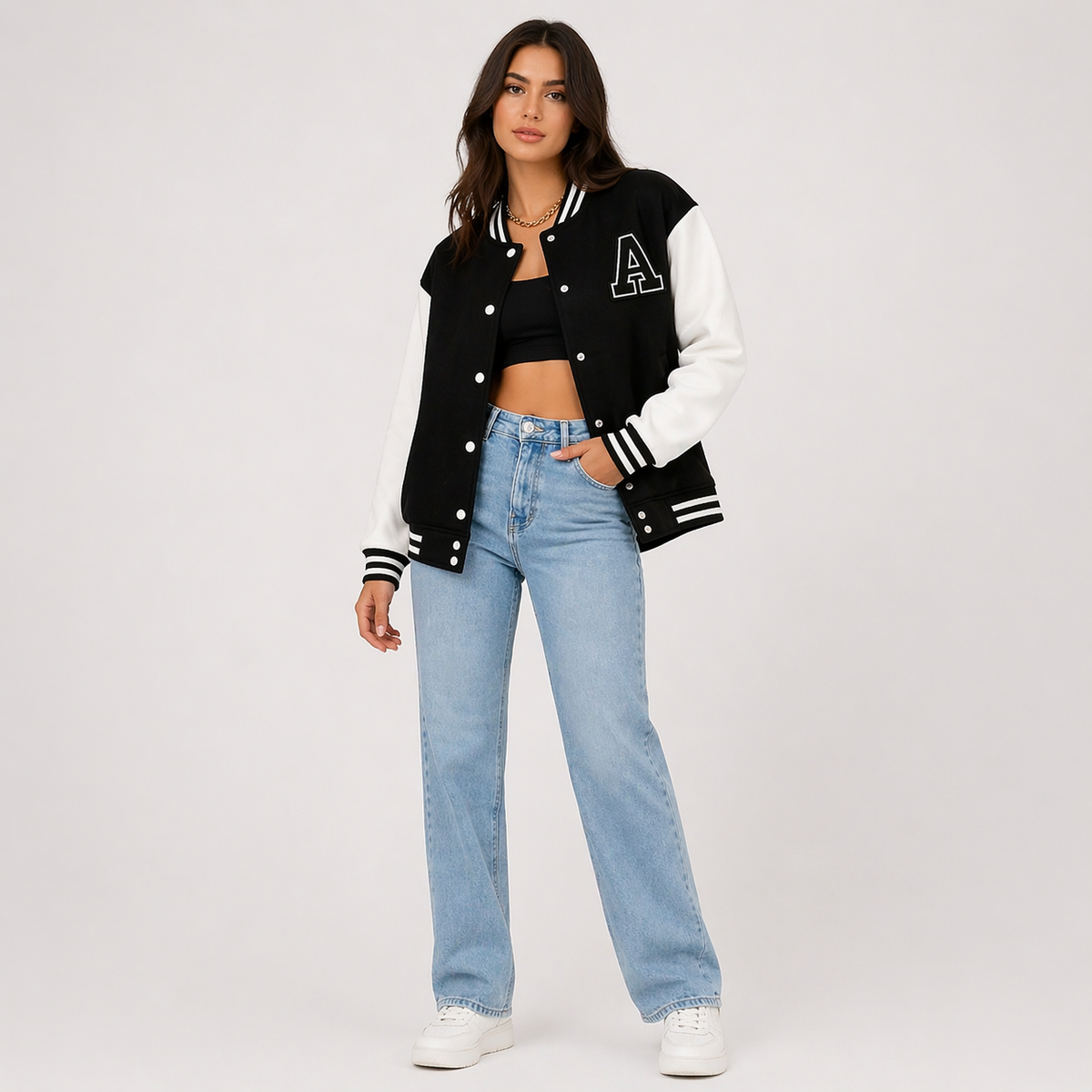 Black varsity bomber jacket with white contrast sleeves, snap buttons, striped rib trim