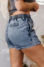 Dusk blue denim shorts with elastic waist, flap-style front pockets and short hem