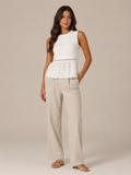Women's white lace peplum tank top with lace hem and beige wide-leg linen pants