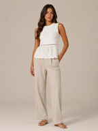 Women's white lace peplum tank top with lace hem and beige wide-leg linen pants