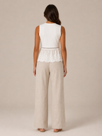 Women's white sleeveless peplum tank top and beige wide-leg linen pants, back view