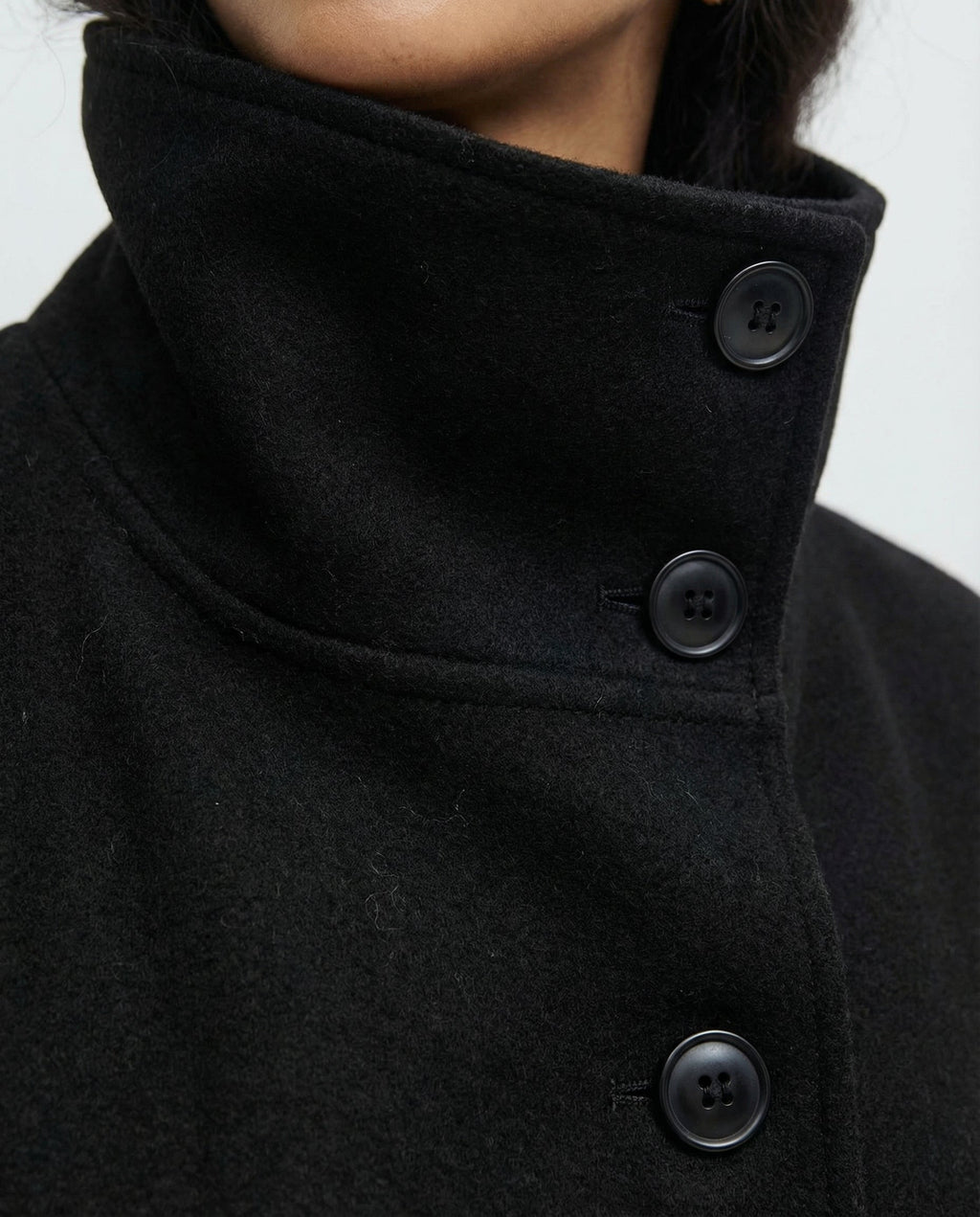 Women's wrap coat collar close-up with button placket, black