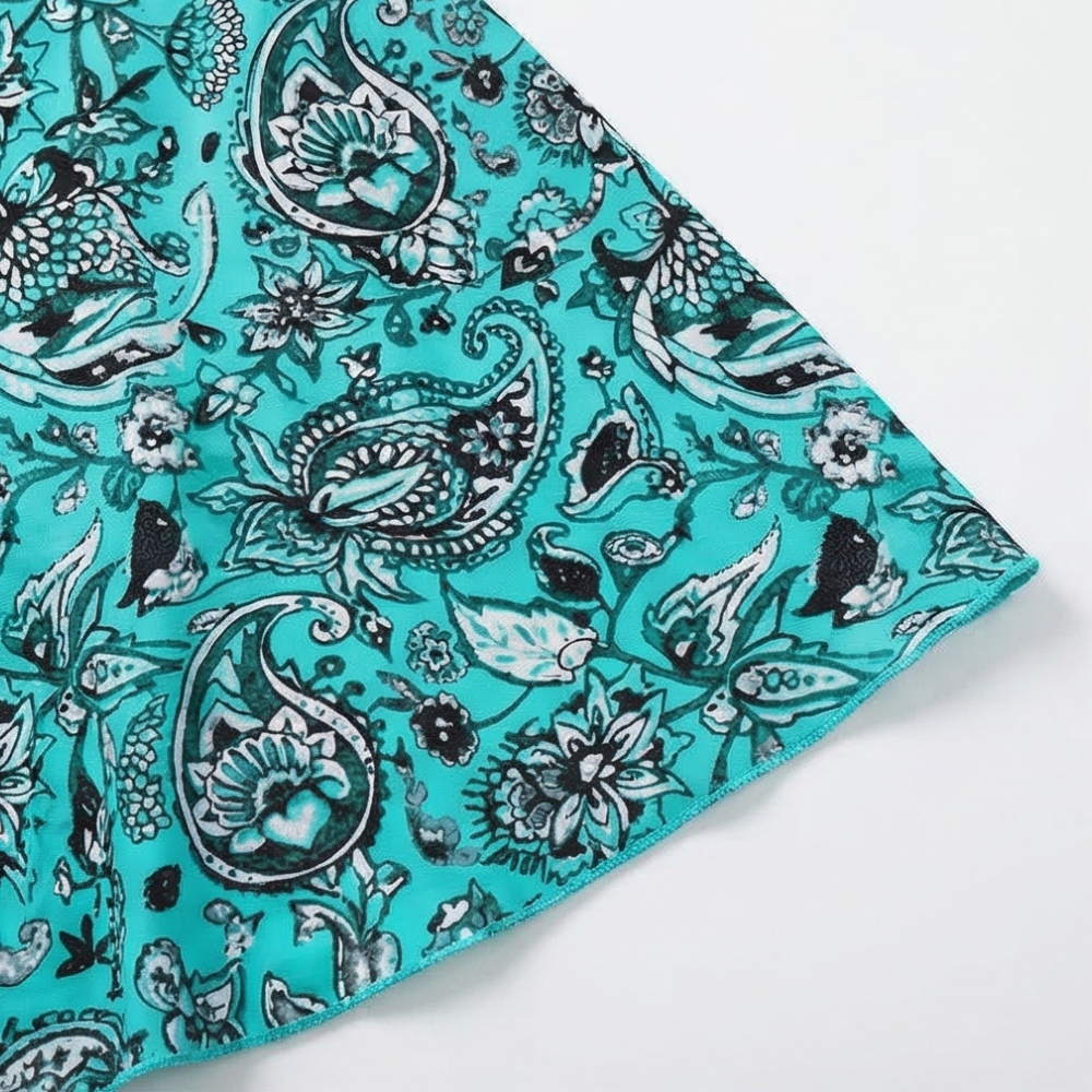Paisley patterned swim dress fabric with teal trim at angled hem