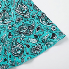 Paisley patterned swim dress fabric with teal trim at angled hem