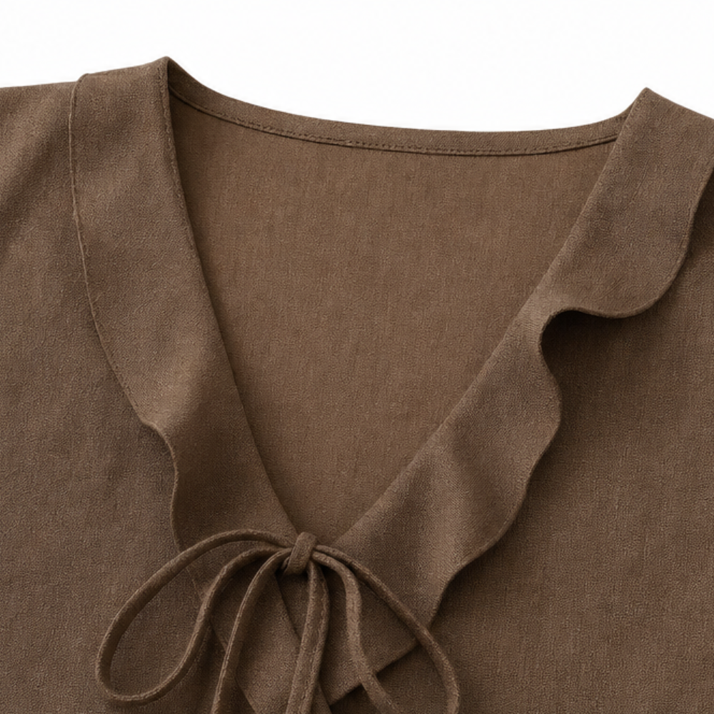 Brown sleeveless V-neck blouse with ruffle edging and tied bow at center