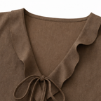Brown sleeveless V-neck blouse with ruffle edging and tied bow at center