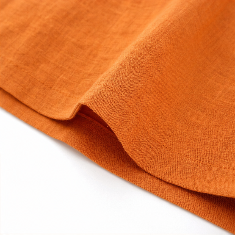 Orange linen-look fabric detail with side seam and curved hem edge