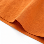 Orange linen-look fabric detail with side seam and curved hem edge