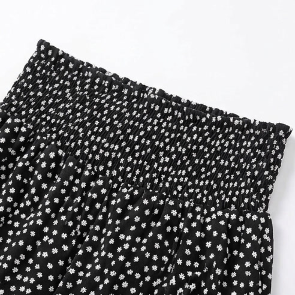 Black smocked wide-leg trousers with white tiny flower print and elastic waistband