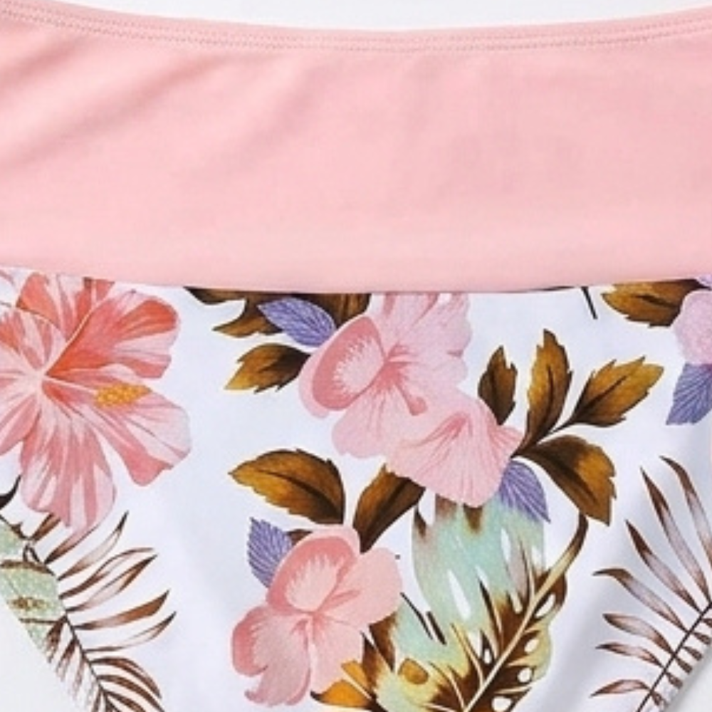 Floral high-waist bikini bottoms with pink waistband and side trim, close-up