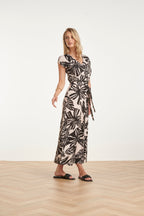 Women's black maxi dress with off-white leaf print and wrap V-neck, side tie waist