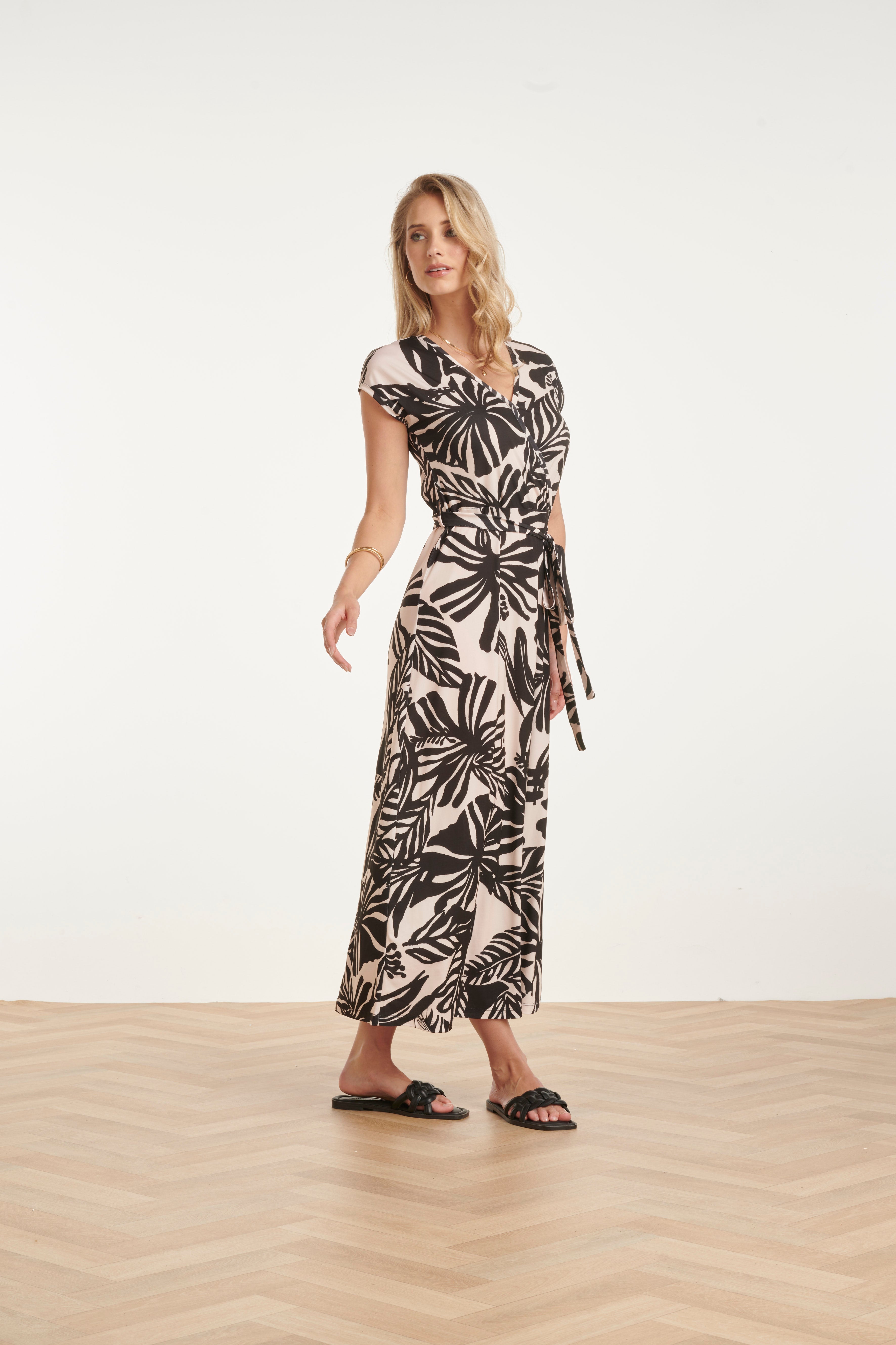 Women's black maxi dress with off-white leaf print and wrap V-neck, side tie waist