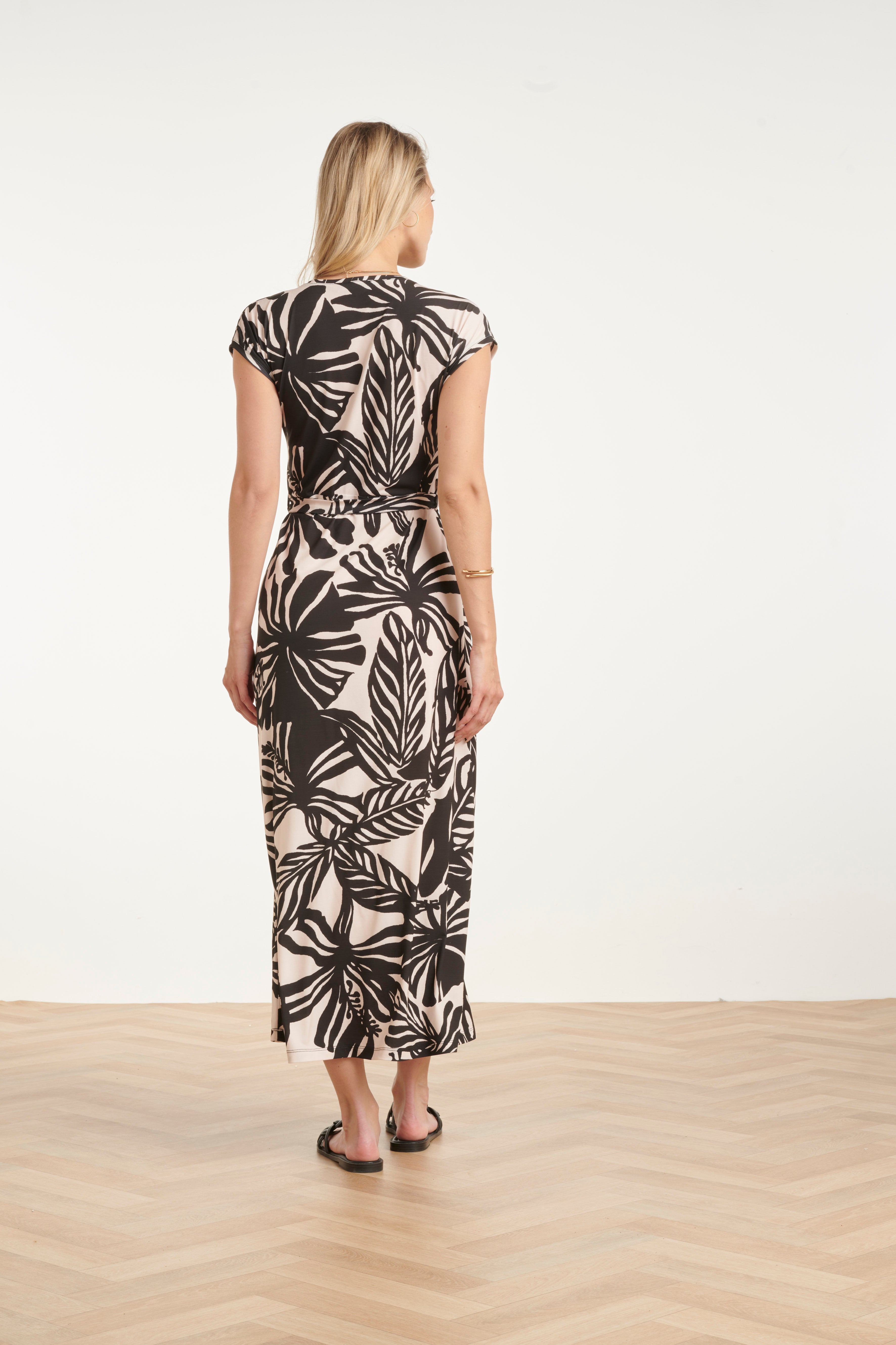 Women's black maxi dress with off-white leaf print, back with fitted waist and tie