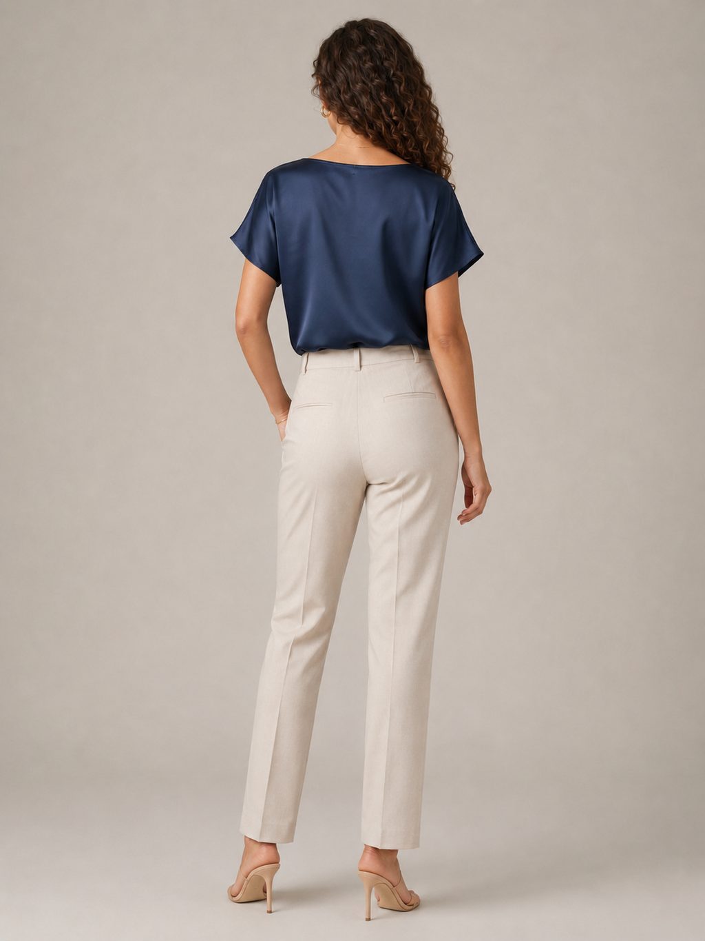 Navy short-sleeve draped-neck blouse shown from the back
