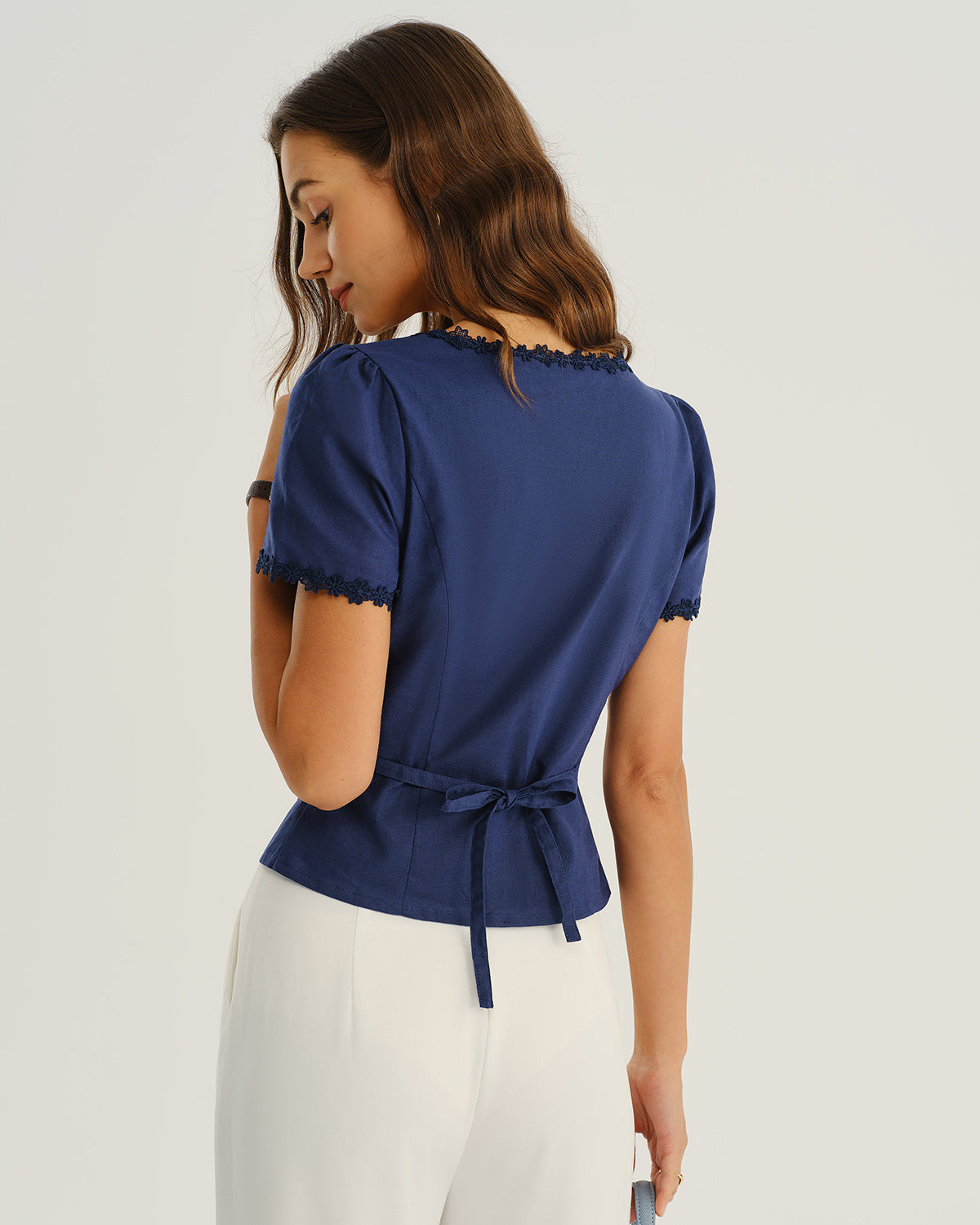 Navy blouse back with lace-trim neckline and waist tie at center