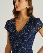 Navy blue cap-sleeve wrap midi dress with V-neck, ruffled tie, and white dot print