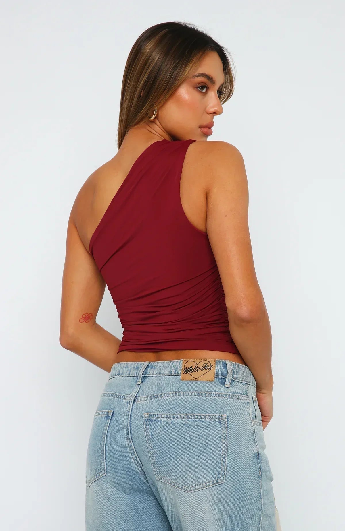 Back view of ruched one-shoulder stretch top, burgundy red, fitted drape detail