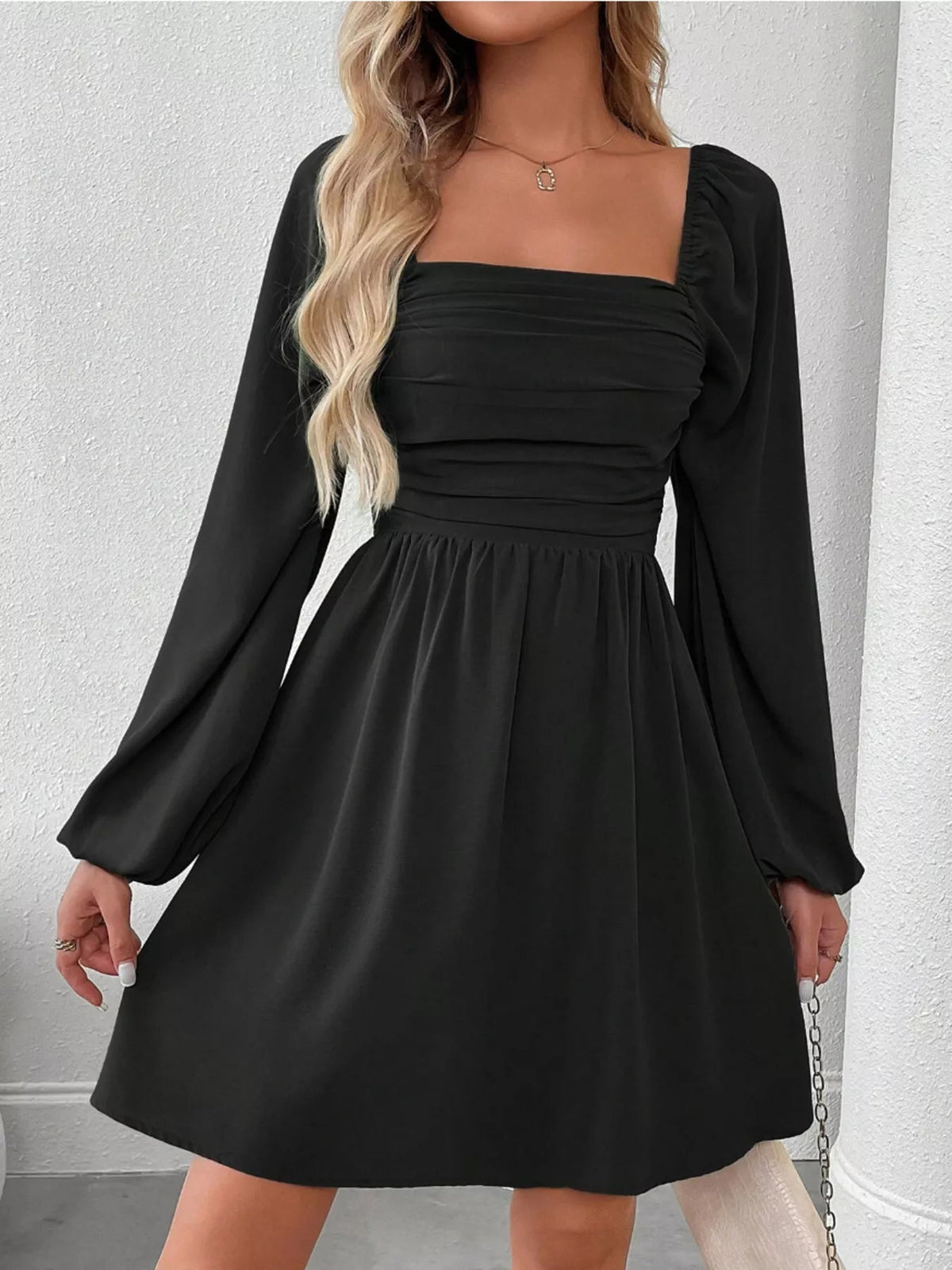 Black A-line dress with ruched square neckline and long puff sleeves