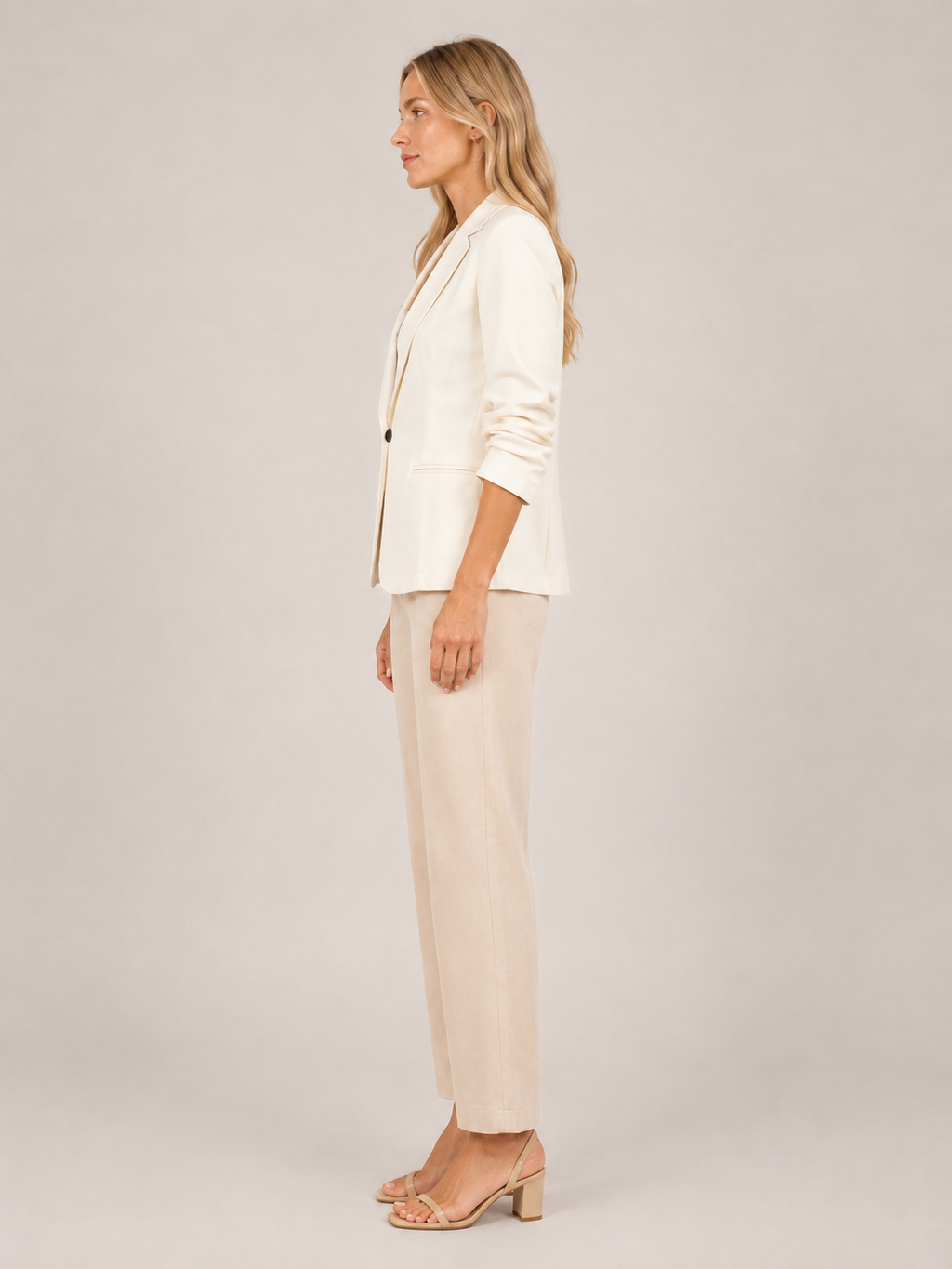 Cream one-button tailored women’s blazer in side profile with notched lapel