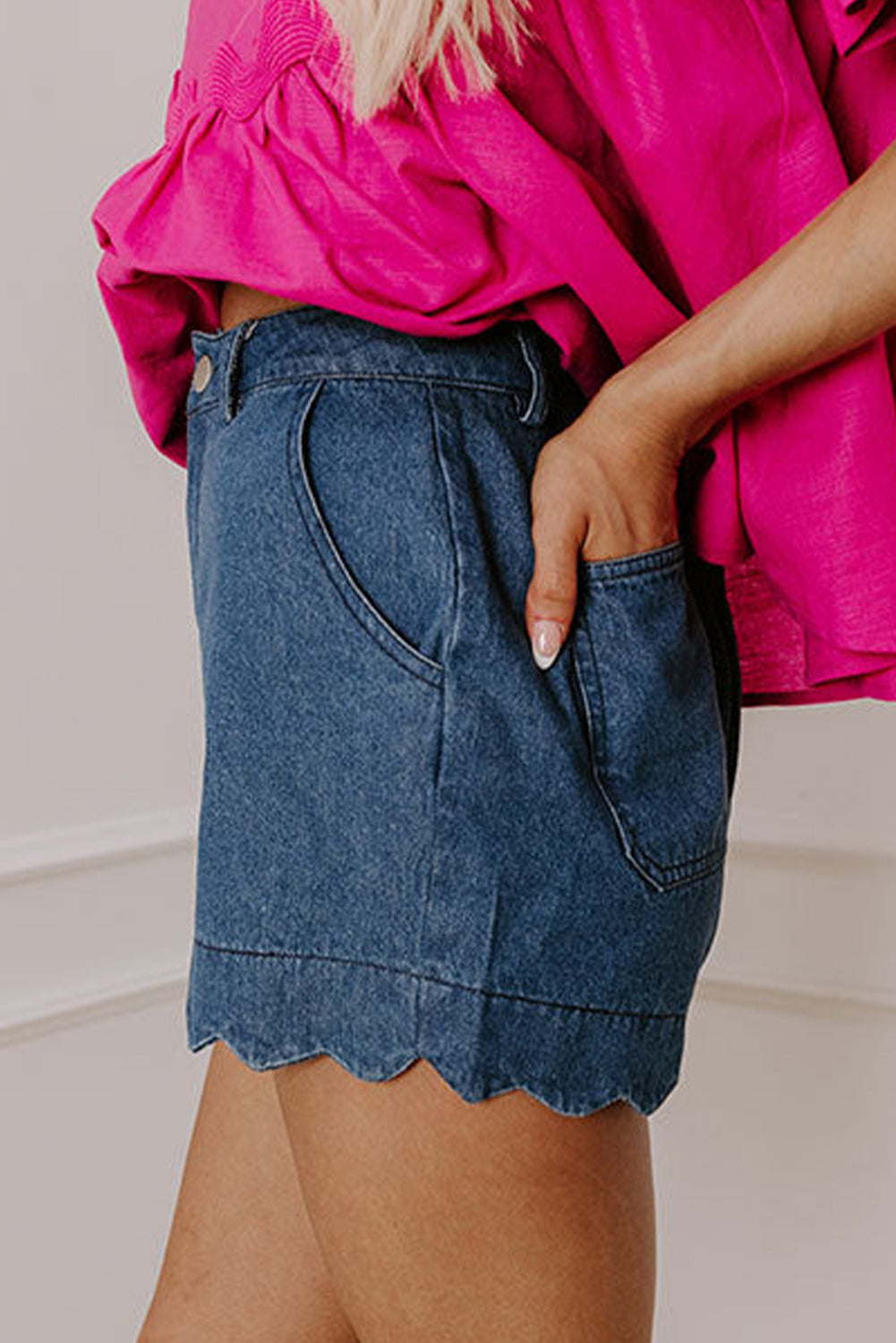 High-waist blue denim shorts with scalloped hem and back patch pocket detail