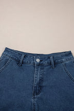 Close-up of high-waist blue denim shorts waistband with button closure and belt loops