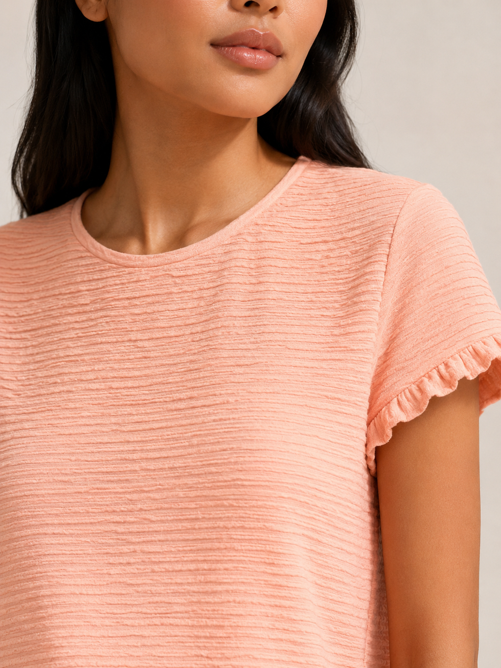 Close-up of soft apricot textured relief-structure short-sleeve crewneck top