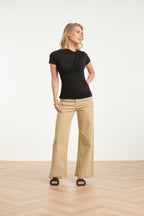 Black draped asymmetrical-neck blouse with short sleeves, smooth fitted look.