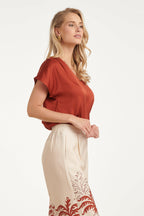 Brick satin V-neck short-sleeve blouse, side view with gentle shoulder drape