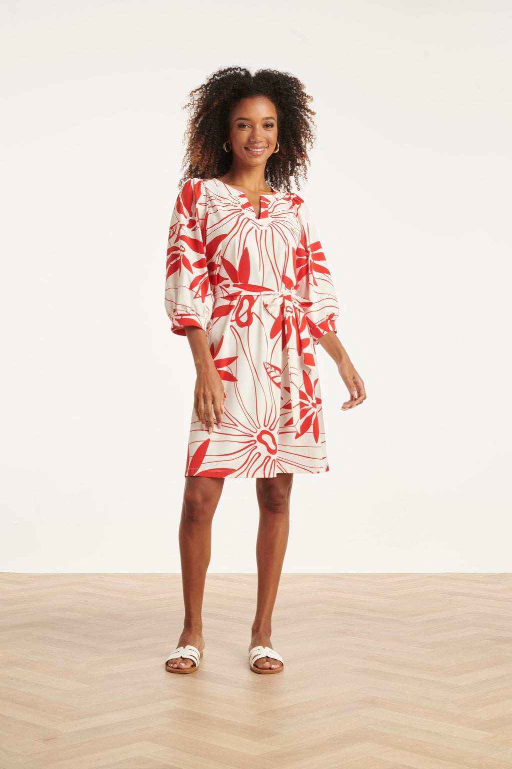 White dress with red floral pattern, tie waist, three-quarter puff sleeves