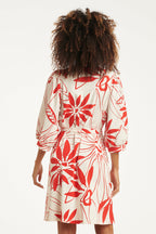 Back view of white dress with red floral print and tie waist, three-quarter sleeves