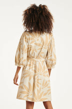 Back view of off-white floral V-neck dress with waist tie and gathered three-quarter sleeves