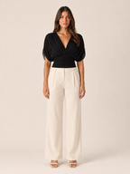 Black V-neck draped blouse with short puff sleeves and ruched wrap front