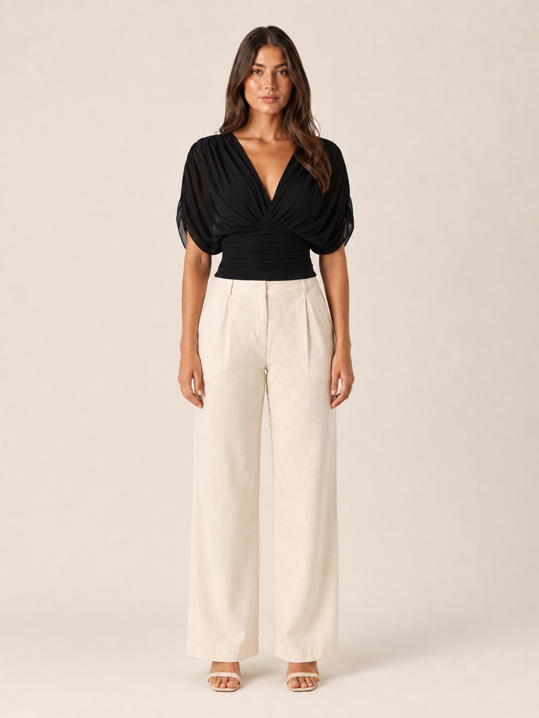 Black V-neck draped blouse with short puff sleeves and ruched wrap front