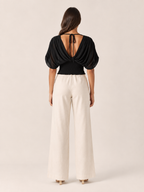 Black V-neck draped blouse with gathered back detail and ruched wrap front