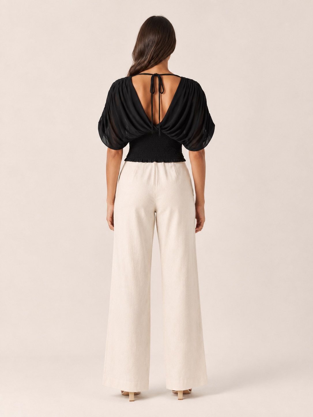 Black V-neck draped blouse with gathered back detail and ruched wrap front