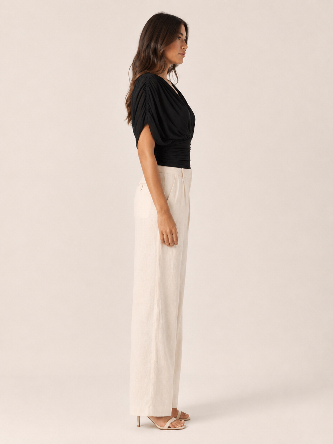Black V-neck draped blouse with draped puff sleeve and ruched wrap bodice (side view)