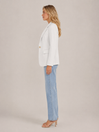White fitted blazer side view with classic lapels and flap pocket