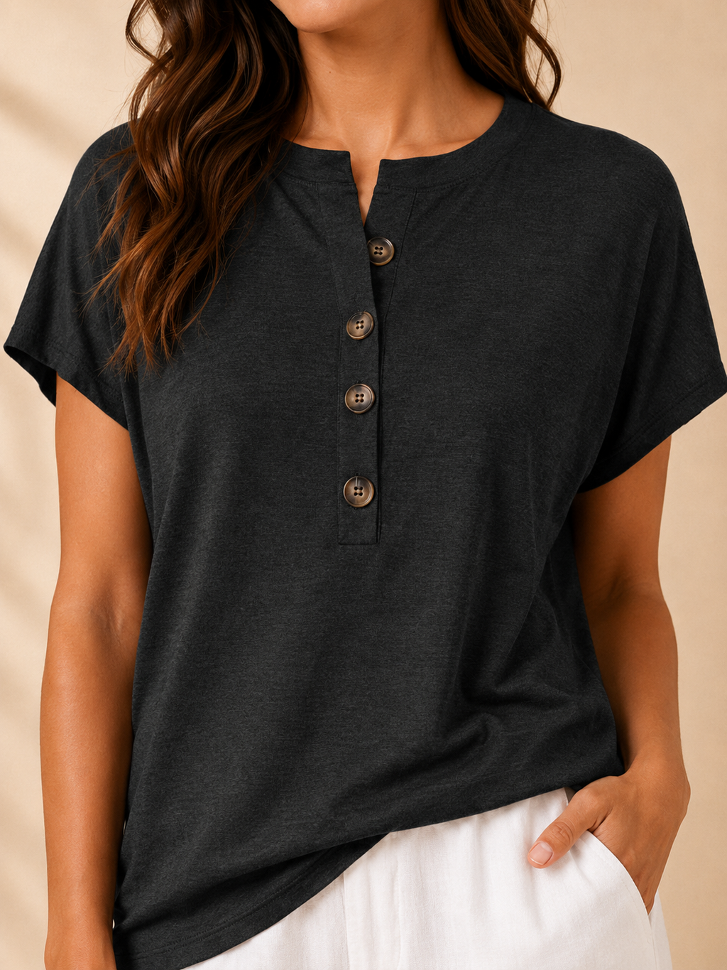Close-up of black split-neck womens top with front buttons and short sleeves