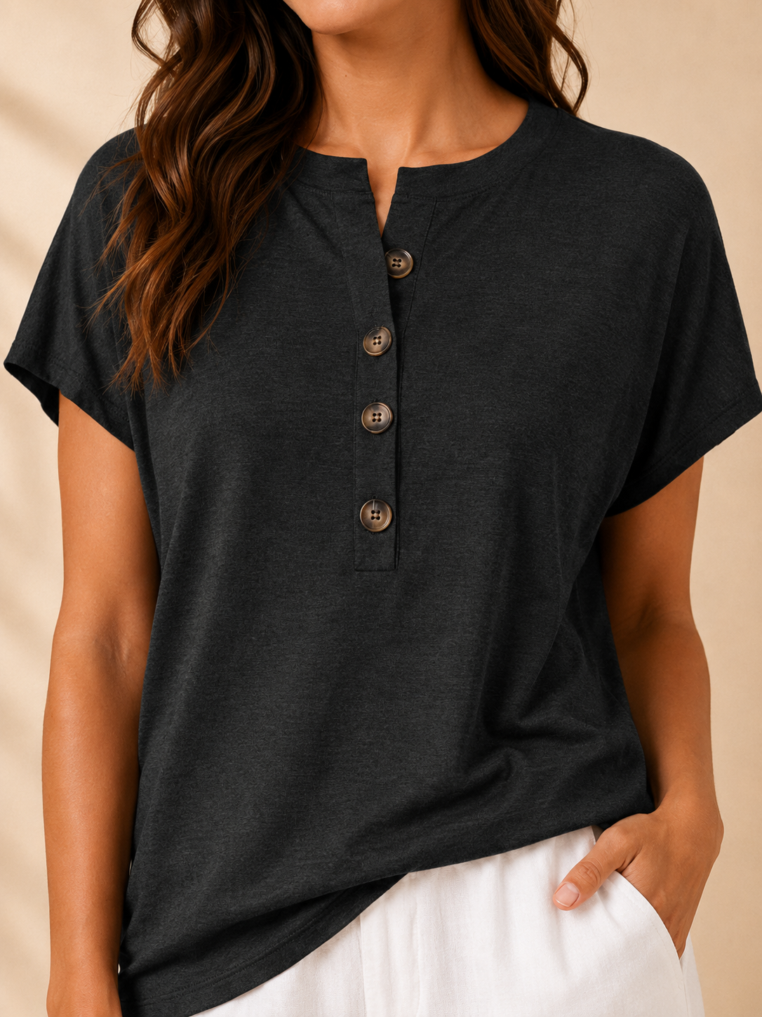 Close-up of black split-neck womens top with front buttons and short sleeves