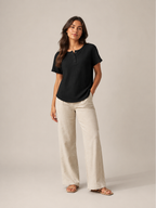 Women’s black short-sleeve button henley top with small button placket at crew neckline
