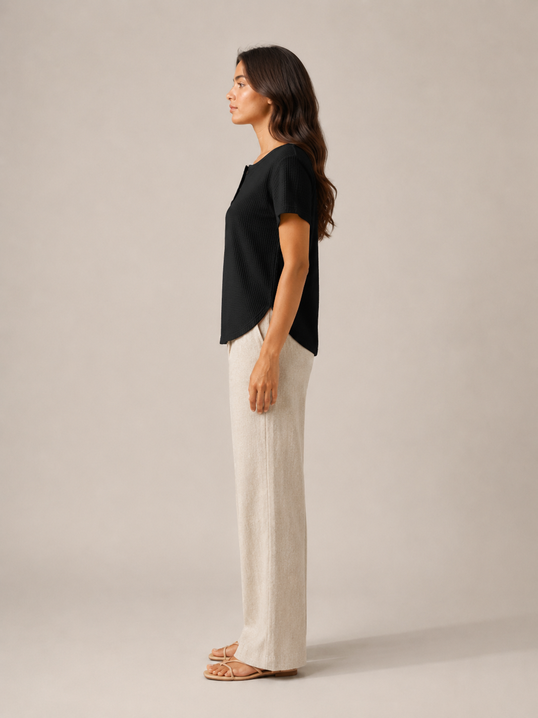 Women’s black short-sleeve button henley top from side view with buttoned neckline