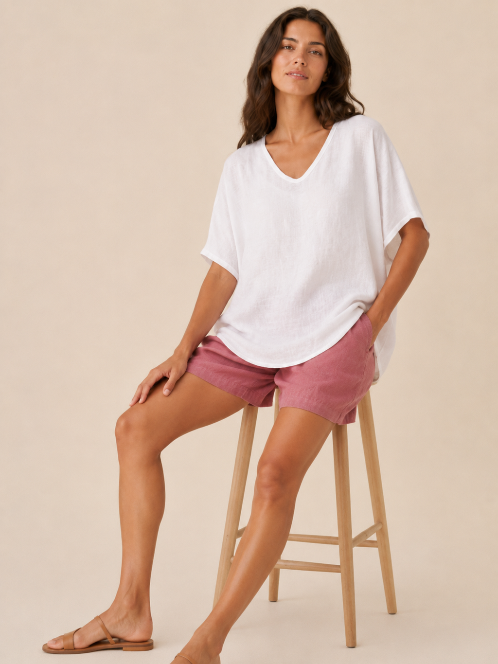 Women’s loose V-neck white top with short wide sleeves and soft, linen-like texture.