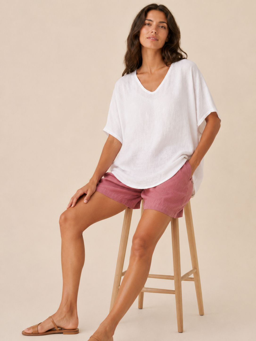 Women’s loose V-neck white top with short wide sleeves and soft, linen-like texture.