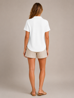 White women's waffle zip polo top, back view with short sleeves and zip neckline